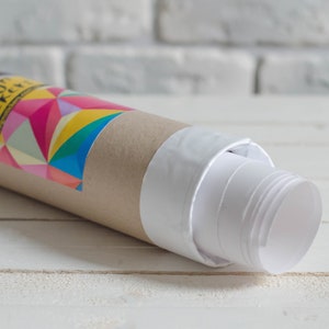 May include: A rolled up poster with a white backing and a brown cardboard tube. The tube has a colorful geometric design and the text "Design Stickery" printed on it.
