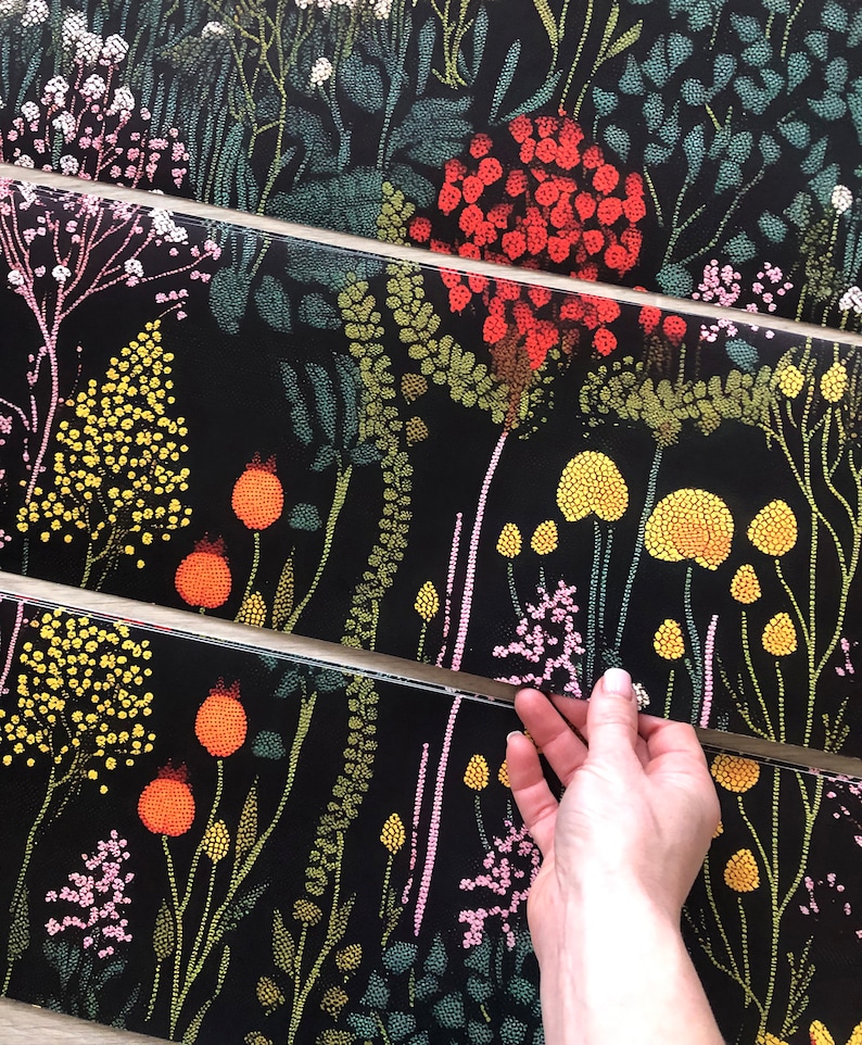 May include: A black background with a repeating pattern of colorful flowers and leaves. The flowers are made up of small dots and the leaves are made up of small lines. The pattern is very detailed and intricate.