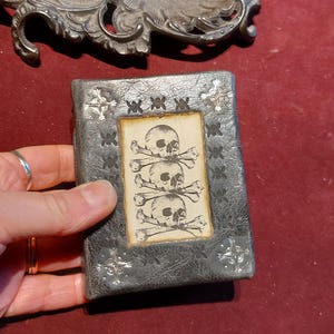Mini libro de calaveras de cuero negro, ideal como regalo de vudú, bruja, terror o gótico.