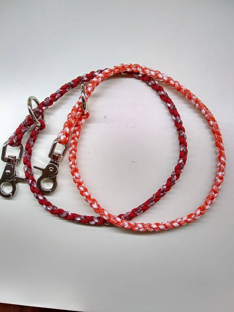 May include: A red and orange braided dog leash with two silver clips.