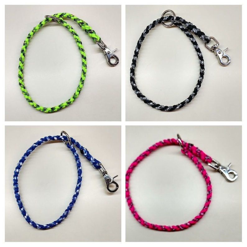 May include: Four braided dog leashes with metal clips. The leashes are in the colors green, black, blue, and pink.