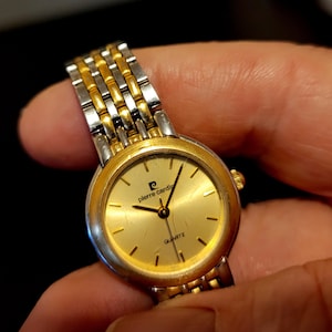 Ladies gold tone wrist watch with round gold face and gold numbers, Pierre Cardin quartz wrist watch