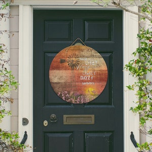 May include: A round wooden sign with a rustic, weathered look. The sign features a colourful sunset background with a windmill silhouette and the text "Those Lazy, Hazy, Crazy Days of Summer".
