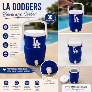 May include: A blue and white LA Dodgers beverage cooler featuring a 3D printed design, a white carrying handle, a white lid, and a leak-resistant spout. The cooler displays the LA logo on the front and includes text detailing features like insulated design, BPA free materials, and easy carry handle.