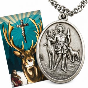 May include: A silver-toned oval pendant with a detailed relief of a saint, deer, and dog, suspended from a chain. A card with a deer and a religious scene is visible to the left. The pendant is marked "ITALY".