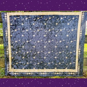 May include: A dark blue celestial tapestry with a gold border and celestial pattern. The design features gold stars, crescent moons, and constellations. The border includes a repeating moon phase design.