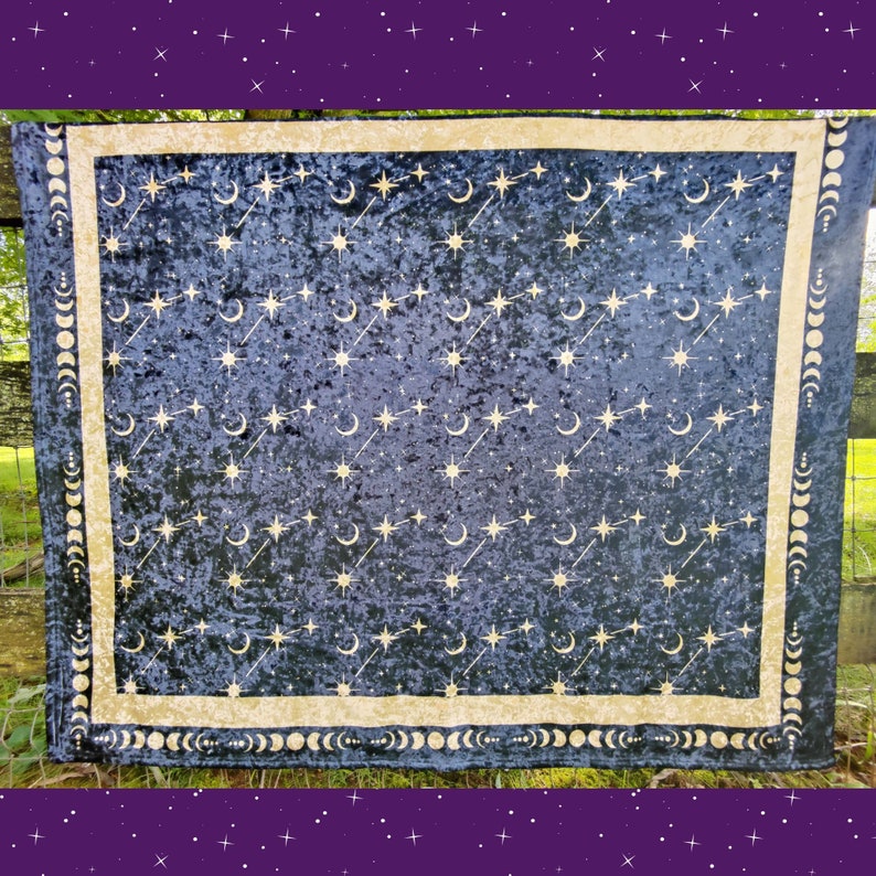 May include: A dark blue celestial tapestry with a gold border and celestial pattern. The design features gold stars, crescent moons, and constellations. The border includes a repeating moon phase design.