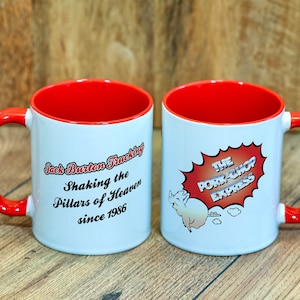 Op de afbeelding: Twee witte keramische mokken met rode handvatten en rode binnenranden. De ene mok heeft de tekst "Jack Burton Trucking Shaking the Pillars of Heaven since 1986". De andere mok heeft een cartoon varken met de tekst "The Pork-Chop Express".