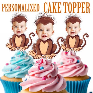 May include: Three personalized cake toppers featuring a baby's face on a monkey cartoon. The monkey is brown with a brown tail and is sitting down. The baby's face is visible in the center of the monkey's head. The cake toppers are printed on white cardstock.