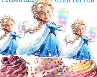 Op de afbeelding: Gepersonaliseerde cupcake topper met een cartoon afbeelding van een meisje dat verkleed is als Elsa uit Frozen, die een regenboog nummer 5 vasthoudt. De topper is op een cupcake met roze en blauwe frosting en kleurrijke sprinkles.
