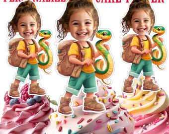 May include: Personalized cupcake toppers featuring a cartoon image of a child wearing a yellow shirt, green pants, and a brown backpack, holding a green snake. The toppers are on top of cupcakes with pink, blue, and white frosting.