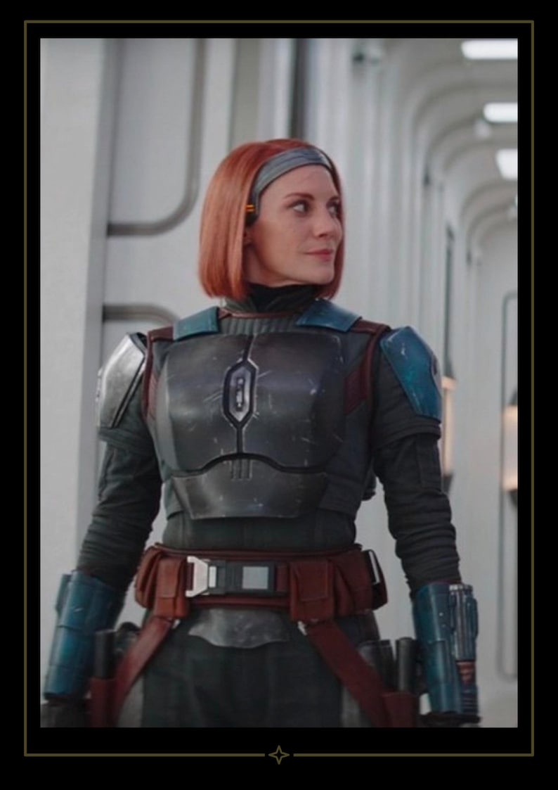 May include: A person with shoulder-length red hair wearing dark gray chest armor with blue shoulder plates, blue gauntlets, and a brown utility belt. The armor features a central vertical emblem on the chest plate and a dark long-sleeved undersuit.
