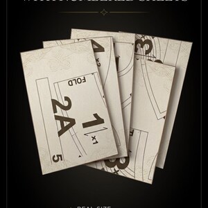 May include: A set of beige paper sewing patterns with black printed numbers and lines. The text reads REAL SIZE PATTERNS WITH NUMBERED SHEETS, REAL SIZE, A4 / US LETTER, and EASY TO ASSEMBLE. The sheets are layered, showing labels like 2A, 1, 4, and 3.
