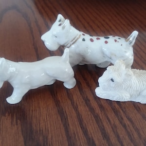 3 figuras de perros blancos