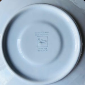 May include: White porcelain saucer with a Longchamp logo and the words "Decors Inalterables" and "Fait en France".