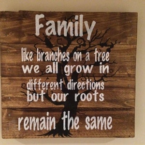 May include: A wooden sign with a black tree silhouette and white text that reads "Family like branches on a tree we all grow in different directions but our roots remain the same."