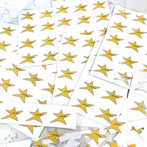 May include: A sheet of stickers with yellow star shapes and the text "Your did it" printed on each star. The stickers are arranged in rows and columns on a white surface.
