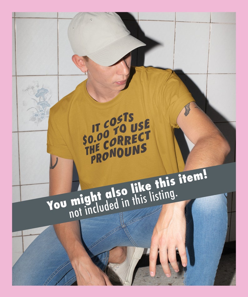 K&ouml;nnte beinhalten: Eine Person tr&auml;gt ein senfgelbes T-Shirt mit dem Aufdruck "IT COSTS 0,00 &euro; TO USE THE CORRECT PRONOUNS". Die Person tr&auml;gt eine hellgraue Baseballkappe und eine blaue Jeans.
