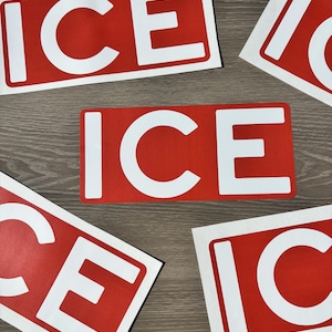 K&ouml;nnte beinhalten: Mehrere rote, rechteckige Aufkleber mit dem Wort "ICE" in wei&szlig;en, fetten Buchstaben liegen auf einer Holzoberfl&auml;che. Die Aufkleber sind in verschiedenen Winkeln angeordnet, einer davon horizontal.