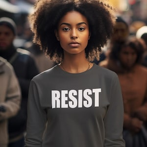 May include: A dark gray sweatshirt with the word "RESIST" printed in white on the front.