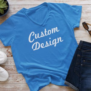 May include: A bright blue v-neck t-shirt with the text "Custom Design" in white lettering.