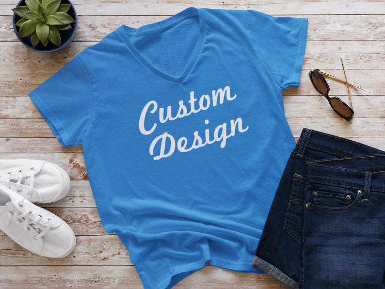 May include: A bright blue v-neck t-shirt with the text "Custom Design" in white lettering.