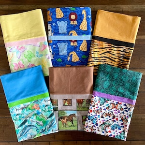 May include: Six different fabric pillow covers with various patterns and colors. The covers feature butterflies, animals, and geometric designs. The covers are all rectangular and have a contrasting trim around the edges.
