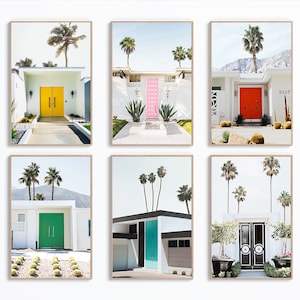 May include: Six framed prints of mid-century modern homes with colorful front doors and palm trees. The homes are white with flat roofs and are set against a blue sky. The doors are yellow, pink, red, green, turquoise, and black.