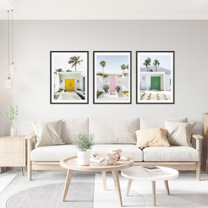 May include: Three framed prints of mid-century modern homes with colorful doors. The first print features a yellow door, the second a pink door, and the third a green door.
