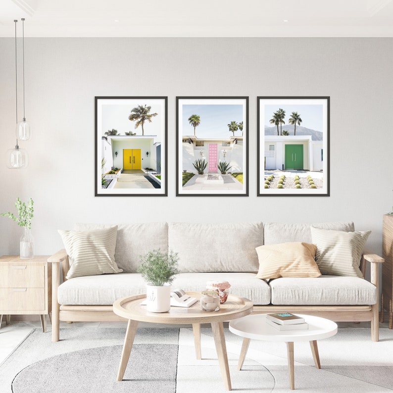 May include: Three framed prints of mid-century modern homes with colorful doors. The first print features a yellow door, the second a pink door, and the third a green door.