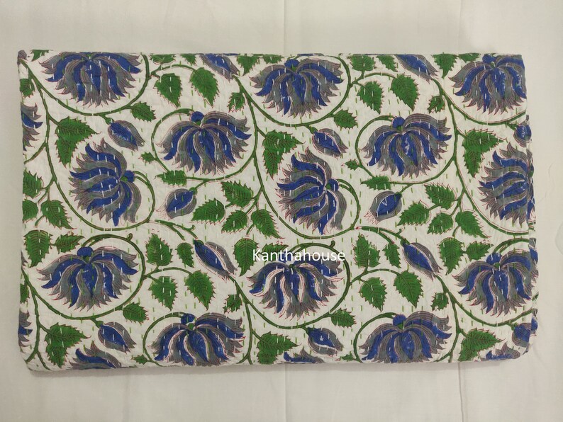May include: White cotton fabric with a floral pattern in shades of blue, green, and gray. The fabric is quilted and has a hand-stitched look. The text "Kantha House" is visible in the lower center of the fabric.