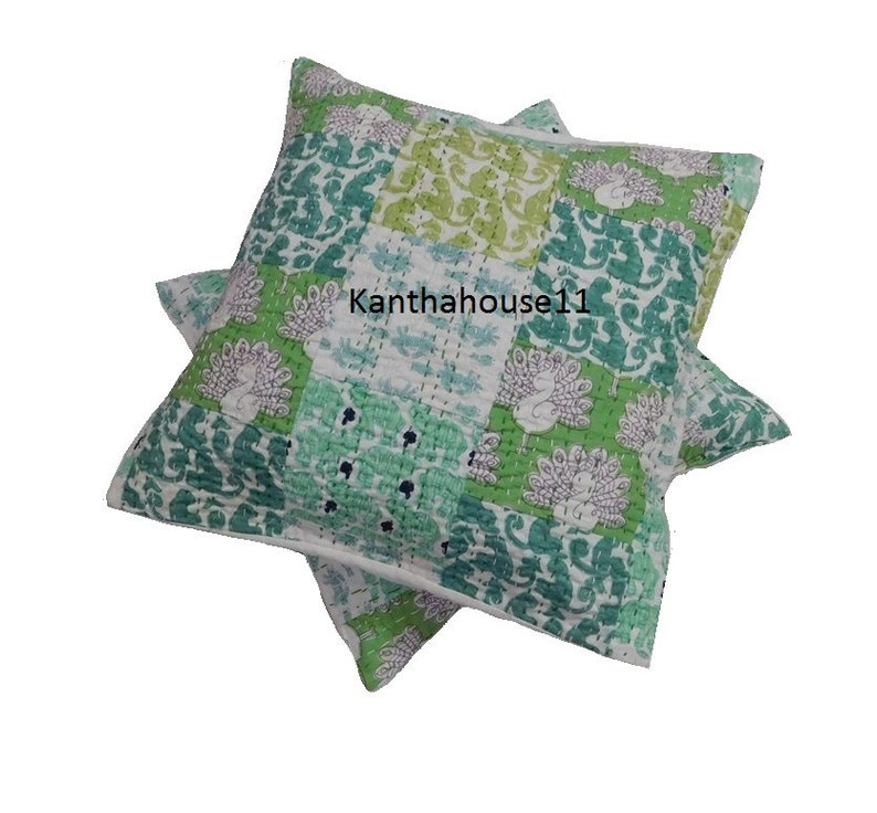 May include: Two green and white patterned throw pillows with a Kantha House 11 logo. The pillows are made of cotton and have a patchwork design.