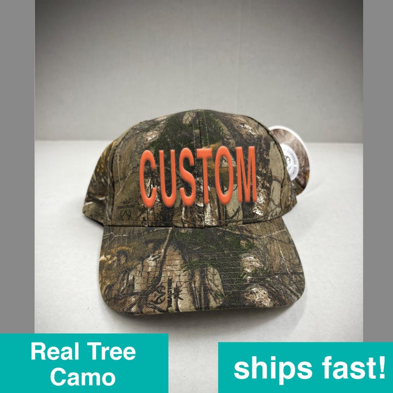 May include: A camouflage baseball cap with the word "CUSTOM" in orange lettering.