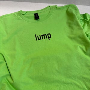May include: A bright green t-shirt with the word "lump" printed in black on the front.