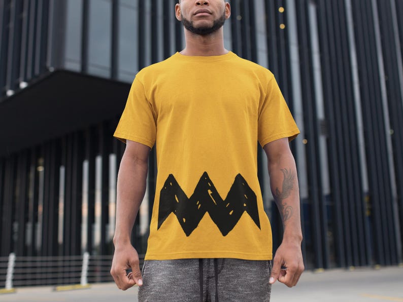 Peut inclure: Un t-shirt jaune avec un motif en zigzag noir sur le devant.