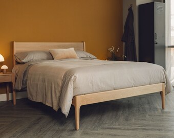 a beautiful, handcrafted bed in solid wood with styled legs and commercial curves in the edges.