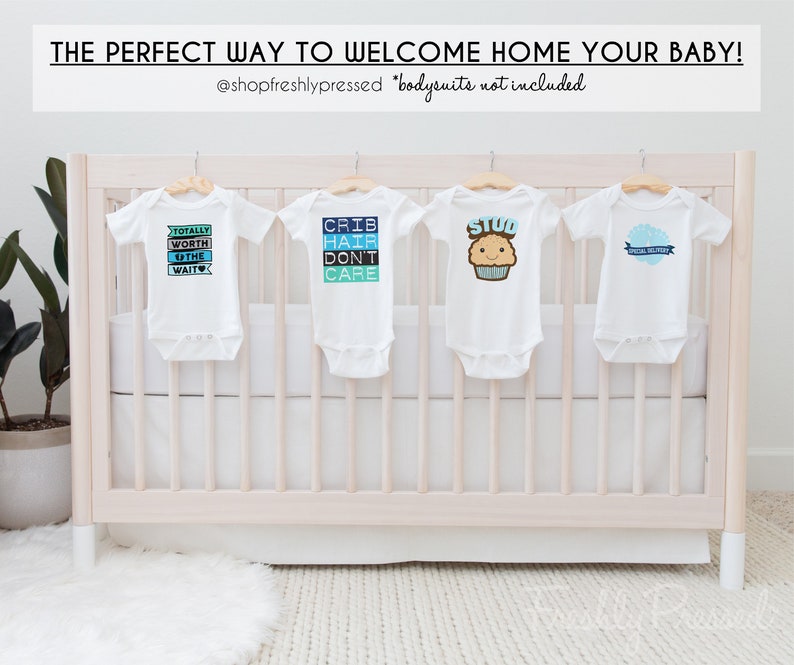 K&ouml;nnte beinhalten: Vier wei&szlig;e Baby-Bodys h&auml;ngen an einem wei&szlig;en Babybett. Die Bodys haben verschiedene blaue und wei&szlig;e Designs mit Text, der "Totally Worth the Wait", "Crib Hair Don't Care", "Stud" und "Special Delivery" lautet.