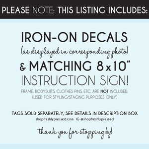 May include: A blue and white sign with the text "PLEASE NOTE: THIS LISTING INCLUDES: IRON-ON DECALS (as displayed in corresponding photo) & MATCHING 8x10" INSTRUCTION SIGN! FRAME, BODYSUITS, CLOTHES PINS, ETC. ARE NOT INCLUDED. (USED FOR STYLING/STAGING PURPOSES ONLY) TAGS SOLD SEPARATELY, SEE DETAILS IN DESCRIPTION BOX shopfreshlypressed.com IG @shopfreshlypressed thank you for stopping by!"