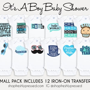 K&ouml;nnte beinhalten: Zw&ouml;lf B&uuml;gelbilder f&uuml;r Baby-Bodys mit verschiedenen Designs in Blau und Wei&szlig; und Texten wie "Mommy's Daddy's Happy Little Camper", "Totally Worth The Wait", "Cute", "Hello World!" und "Cri Hair Don't Care".