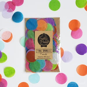 May include: A bag of colorful 1 inch round confetti table sprinkles. The bag is labeled "Freshly Pressed" and contains approximately 500 pieces.