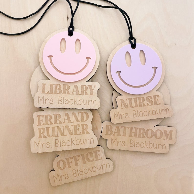 Pu&ograve; includere: Cinque targhette in legno con un design a forma di viso sorridente. Ogni targhetta ha un titolo di lavoro diverso: Biblioteca, Infermiera, Addetto alle commissioni, Bagno e Ufficio. Ogni targhetta include anche il testo "Mrs. Blackburn".