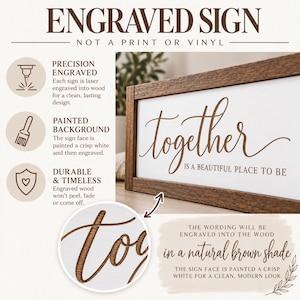 May include: A rectangular wooden sign with a dark brown frame and a white face. The text "together IS A BEAUTIFUL PLACE TO BE" is laser engraved into the wood in a natural brown shade. The sign features a clean, modern aesthetic.