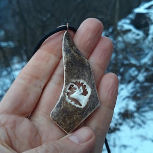 A hand-carved antler necklace with a motif of a white tailed deer - a perfect gift for an outdoor lover!