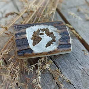 A hand-carved antler brooch with a motif of a deer - Antler carving
