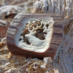 Um broche de chifre esculpido à mão com um motivo de veado/alce