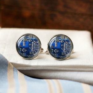 May include: A set of three ceramic mugs with a speckled, matte finish in cream, light grey, and dark grey. Each mug has a simple, minimalist design, suitable for coffee or tea.