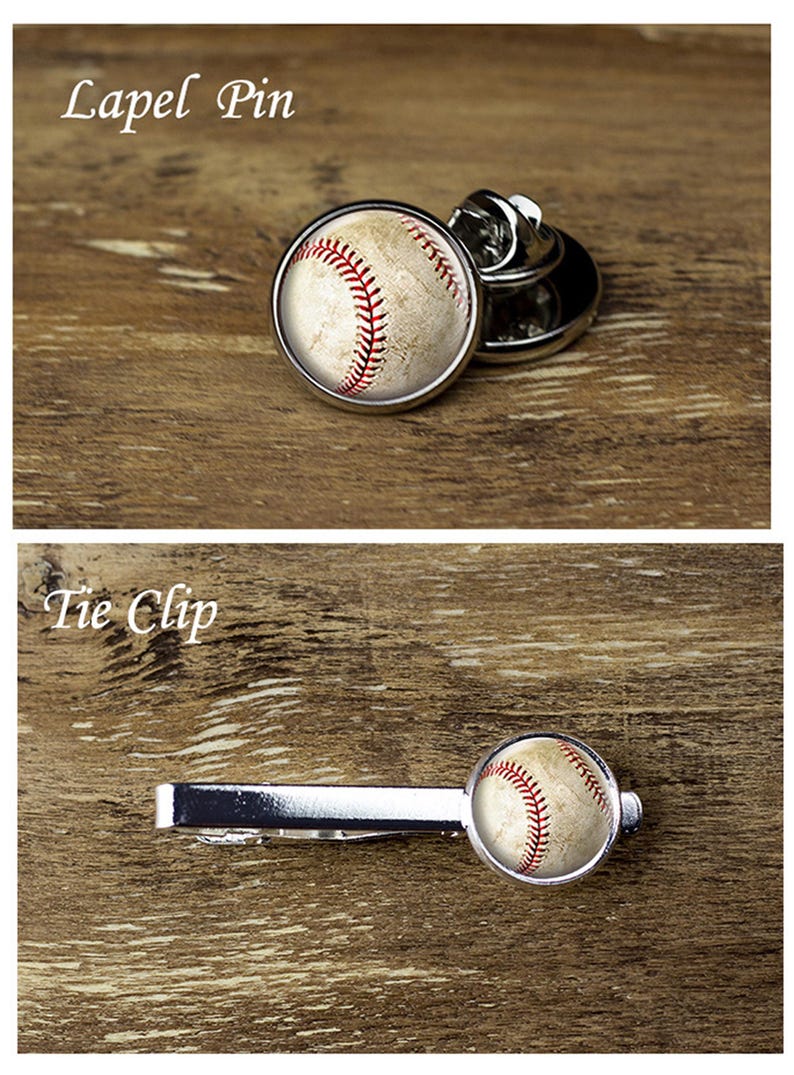 May include: A baseball-themed lapel pin and tie clip. The pin is round with a baseball design, featuring red stitching on a beige background. The tie clip has a similar baseball design. The text "Lapel Pin" and "Tie Clip" are visible.