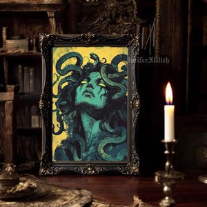 May include: A framed illustration of Medusa, a mythical Greek figure with snakes for hair, against a yellow background. The illustration is in a dark wood frame with ornate details.