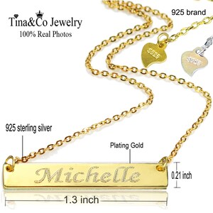 May include: A gold necklace with a personalised nameplate bar pendant that reads "Michelle". The bar is 1.3 inches long and 0.21 inches wide. The chain is made of 925 sterling silver and is plated in gold.