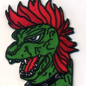 May include: Green and red embroidered patch of a punk rock dinosaur with a spiked collar.